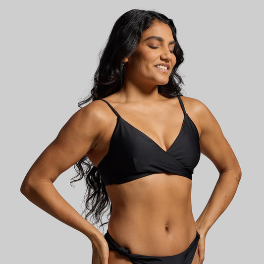 Woman wearing a black bikini against a gray background