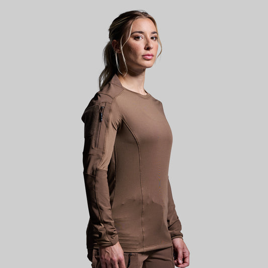 Woman wearing a brown tactical outfit on a gray background