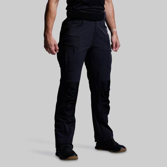 Person wearing black tactical pants on a gray background