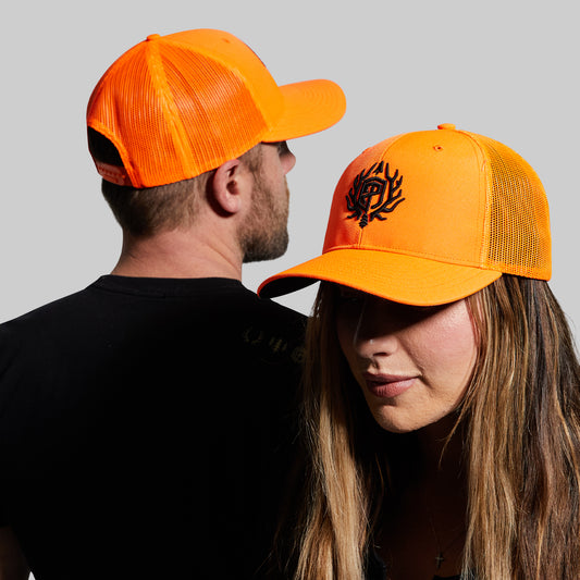 Two people wearing orange caps with a black design on a gray background