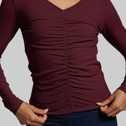 Maroon ribbed long-sleeve top on a neutral background