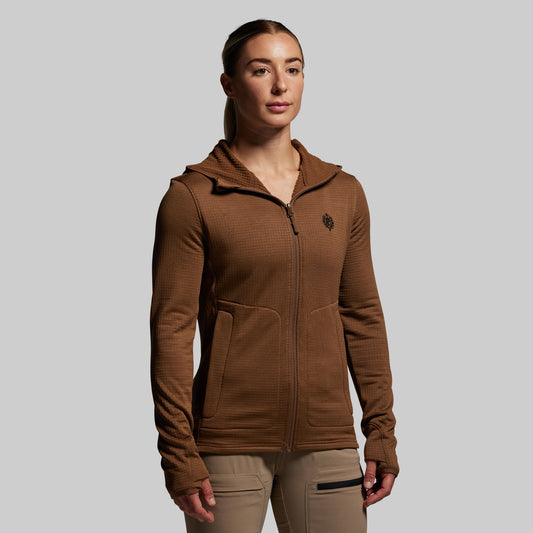 Woman wearing a brown hoodie with a logo on a gray background