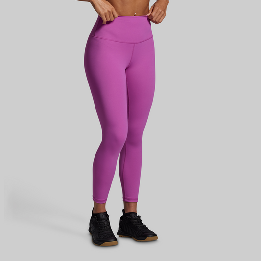 Purple leggings worn by a person on a gray background