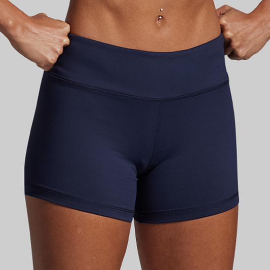 Navy blue athletic shorts worn by a person on a gray background