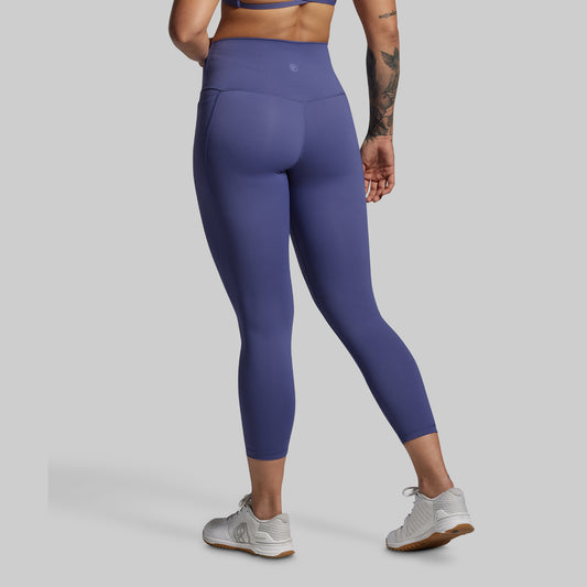Person wearing purple leggings on a gray background