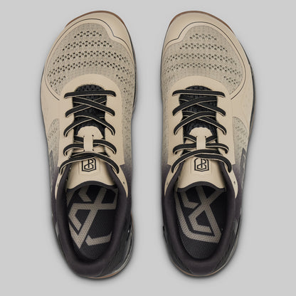 Pair of beige and black athletic shoes on a light gray background