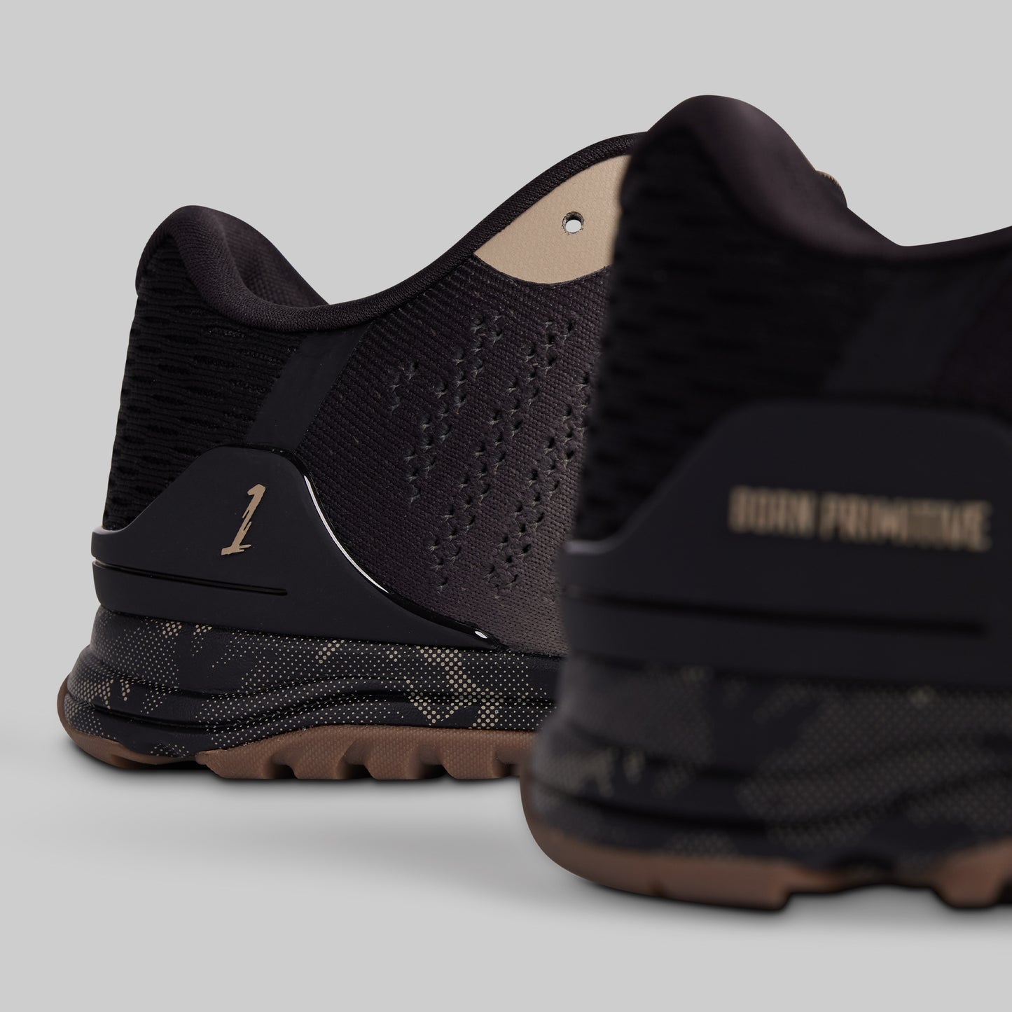 Black athletic shoes with brand name on a gray background