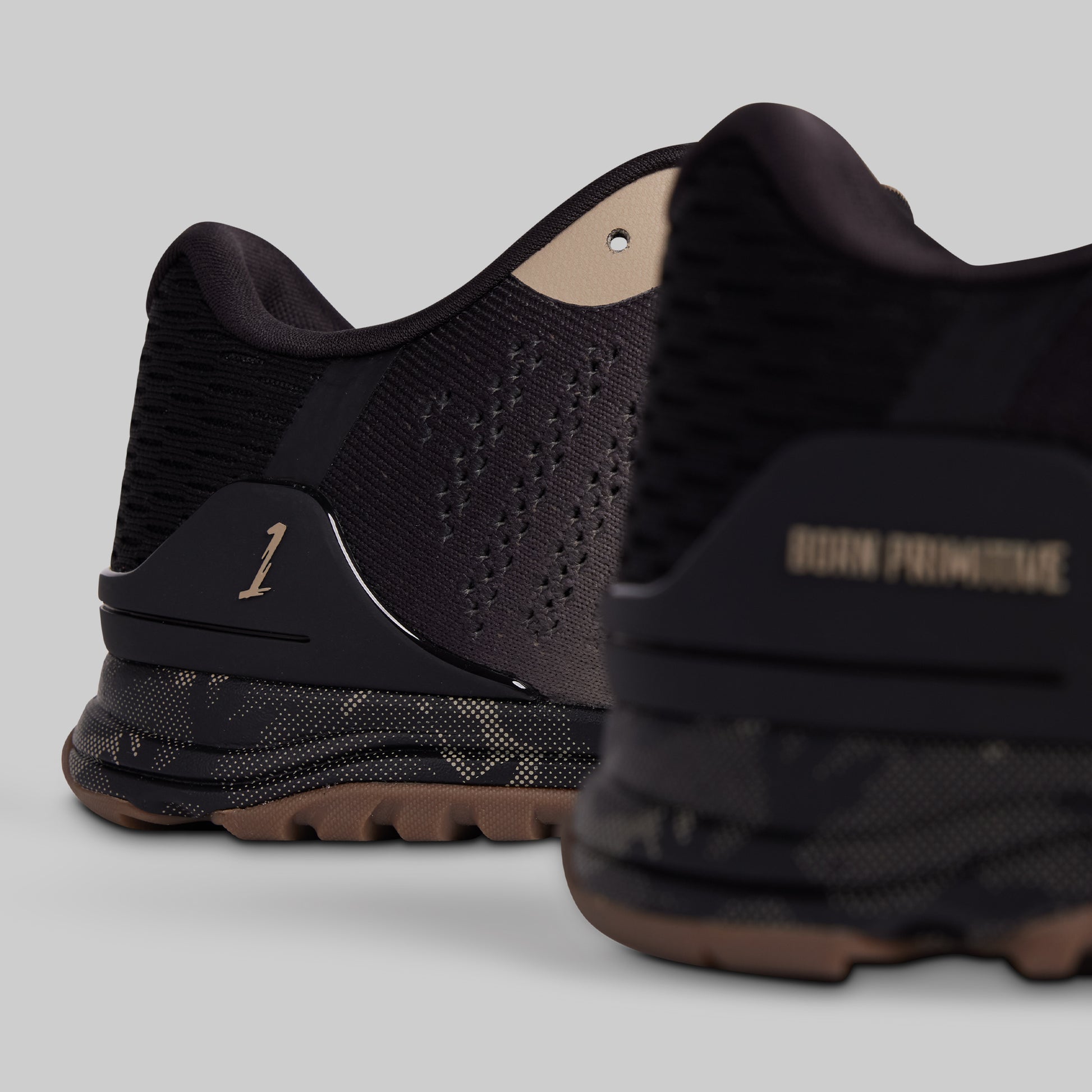Black athletic shoes with brand name on a gray background