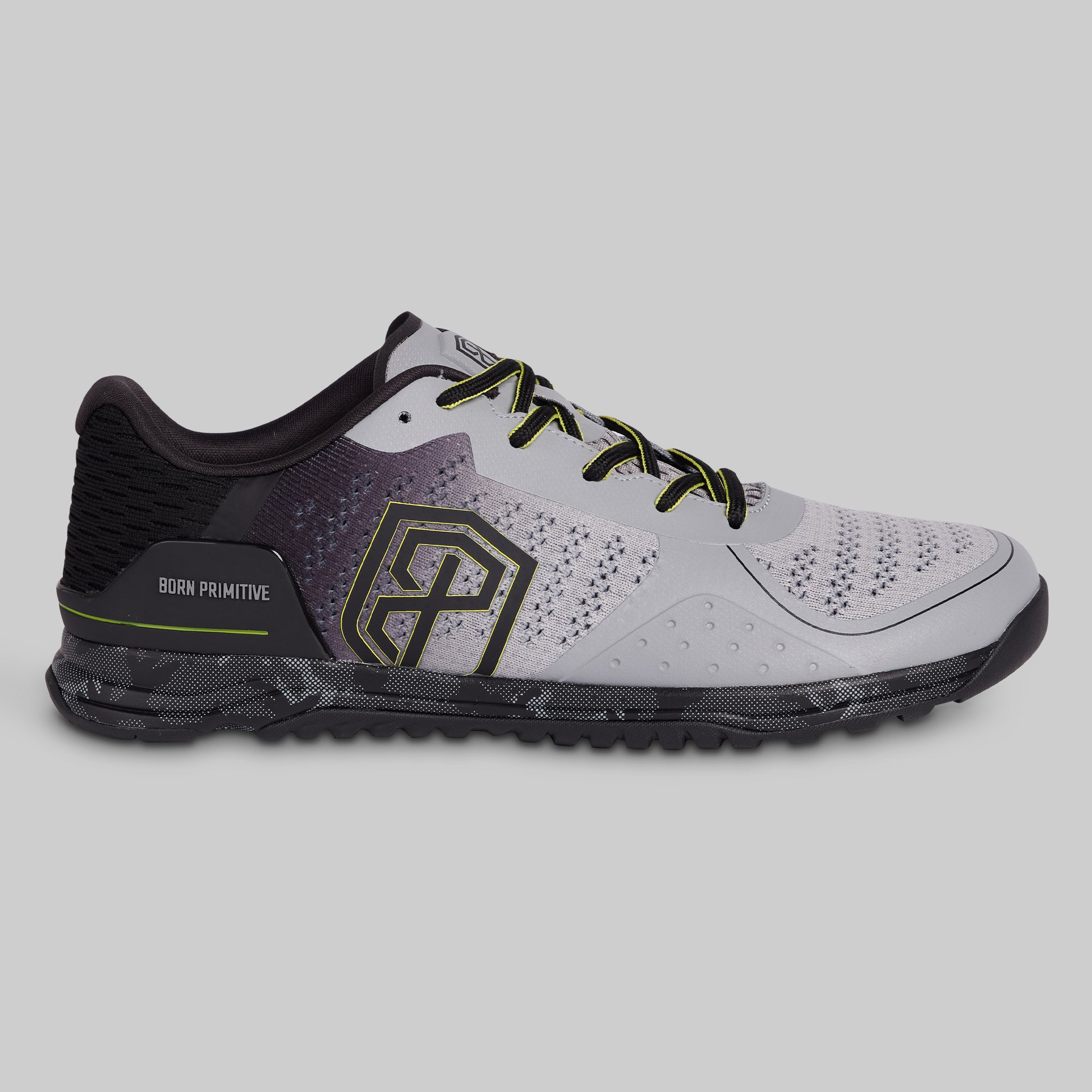 Gray athletic shoe with black and green accents on a gray background