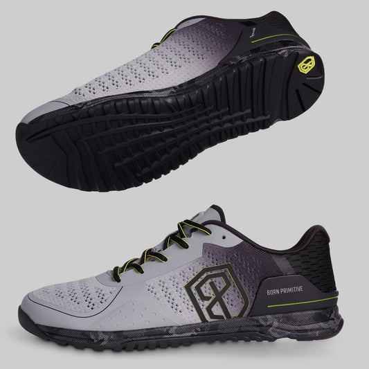 Gray and black athletic shoe with yellow accents on a light gray background