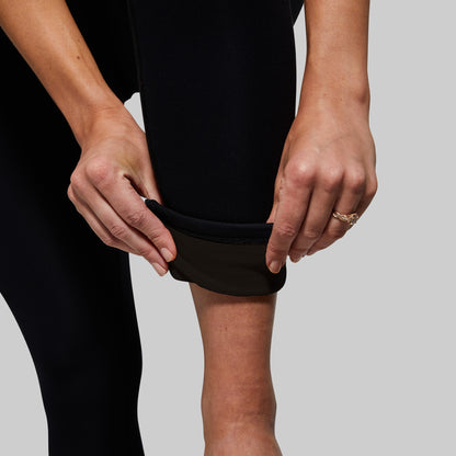 Person rolling ankle cuff to show fleece lining inside leggings