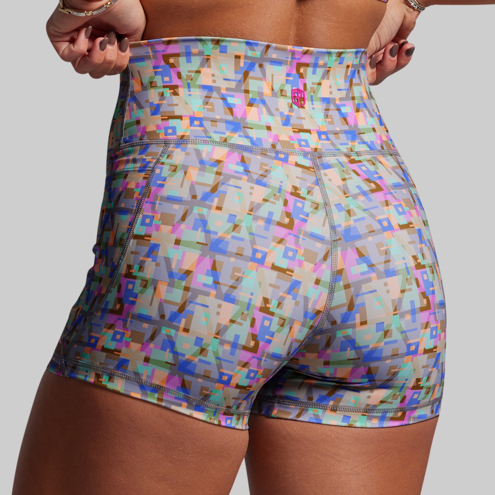 Colorful geometric patterned shorts on a plain background