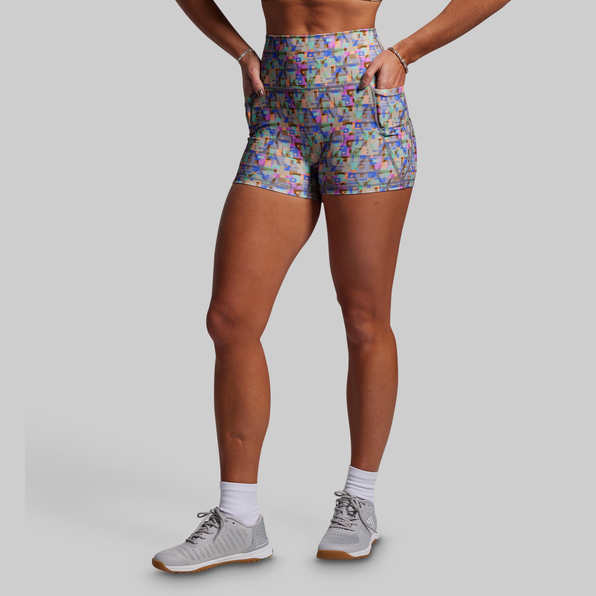 Person wearing colorful patterned shorts on a gray background