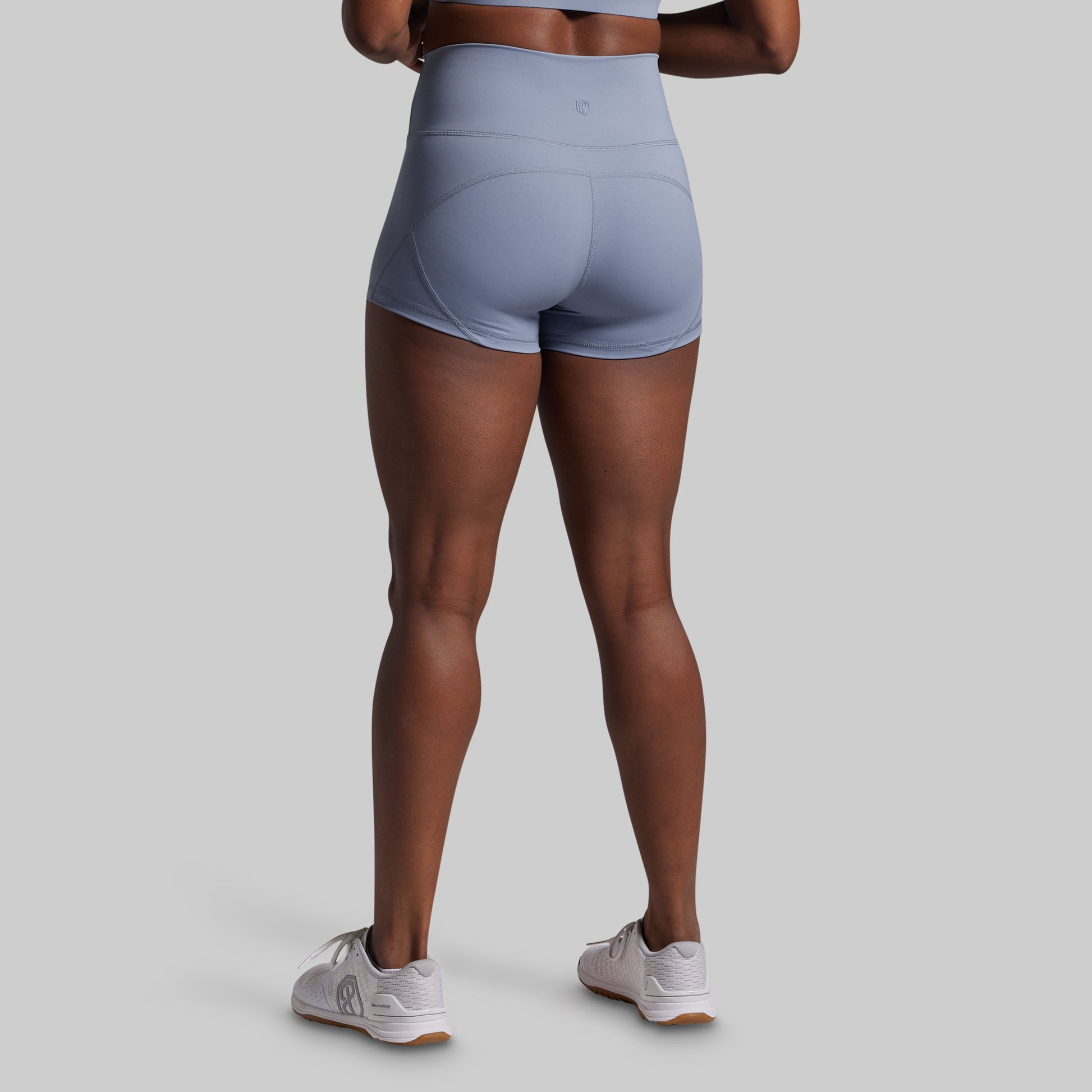 Person wearing light blue athletic shorts on a gray background