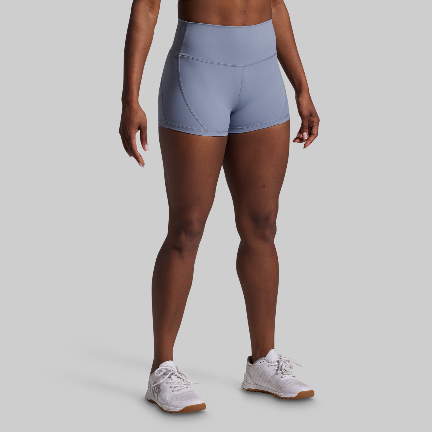 Person wearing light blue athletic shorts on a gray background