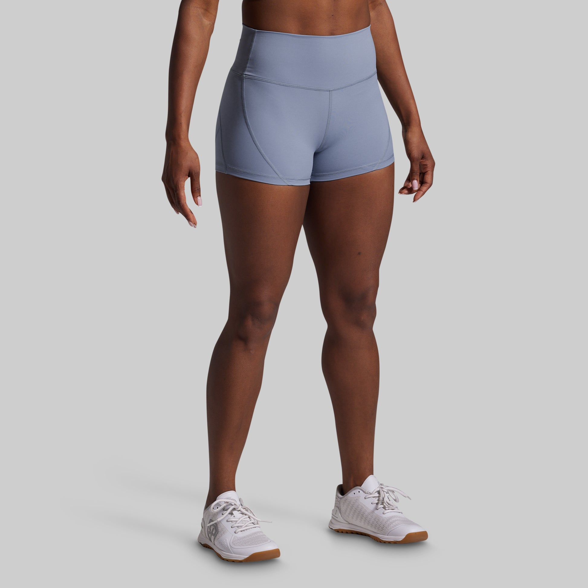 Person wearing light blue athletic shorts on a gray background