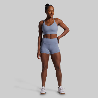Woman wearing a light blue athletic outfit on a gray background
