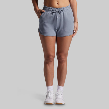 Person wearing gray shorts on a plain background