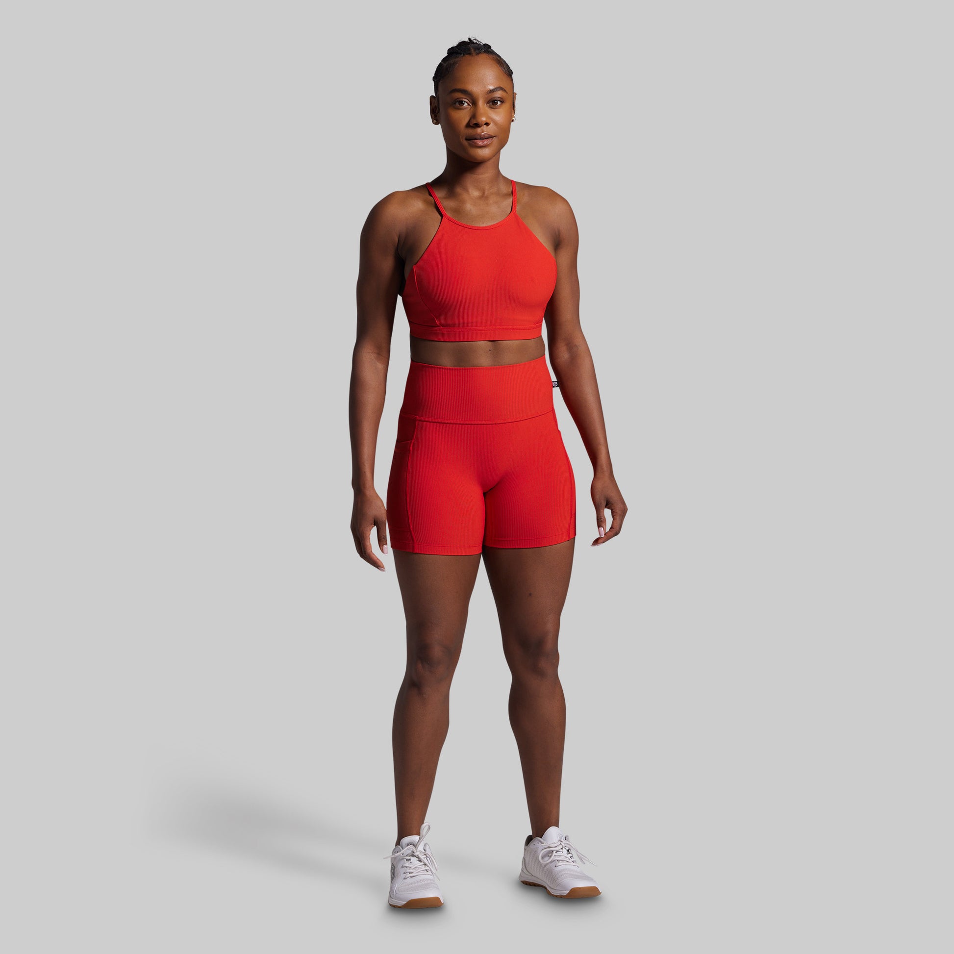 Person wearing a red athletic outfit on a gray background