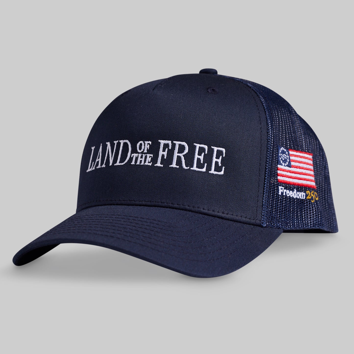 Navy blue cap with 'Land of the Free' text and American flag patch on a gray background