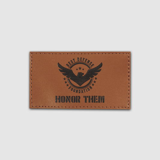 Brown leather patch with engraved text and logo on a light gray background
