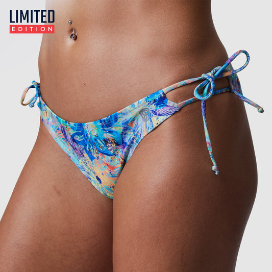 This image features the Heatwave Bikini Bottoms in an eye-catching iridescent iris pattern. The bikini bottom is designed with medium coverage and includes adjustable tie closures on each side, providing a customizable fit.
